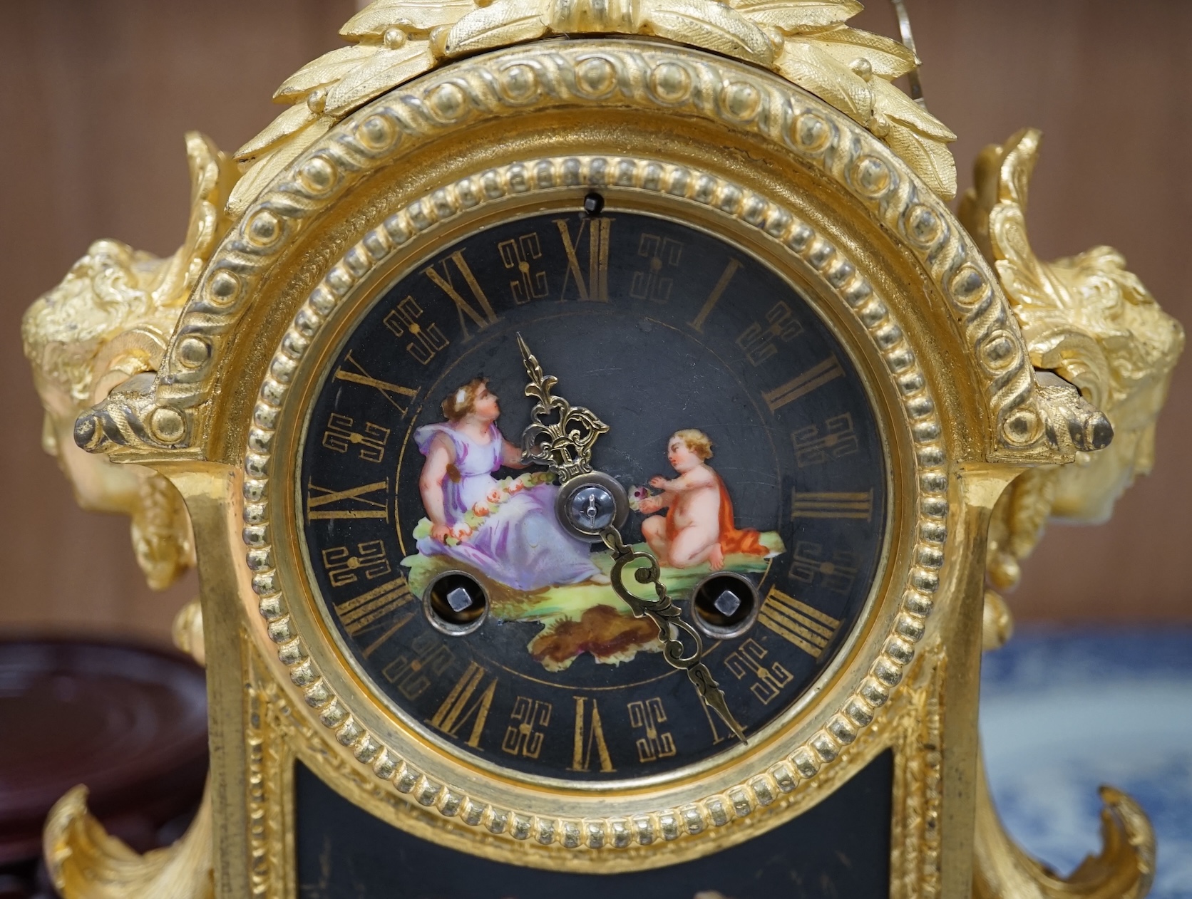 A French ormolu, black figural porcelain mounted mantel clock, 28cm wide x 36cm high. Condition - face and ormolu worn, unknown if clock working.